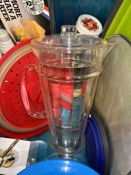 Tote full of miscellaneous household/kitchen items…..2 teal pitchers (acrylic and heavy plastic, collapsible strainer, splatter screen and more