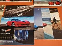 Grouping of Corvette dealership brochures, America sports car magazines, and new roads magazines.