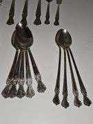 Old company plate flatware possibly Signature Rose pattern. Four dinner forks, four salad forks, five soup spoons, four iced teaspoons, four dinner knives, two serving spoons, one ladle, one cold meat fork, one sugar spoon, and one butter knife. No monogram.  Circa 1940s