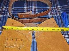 Little cowpoke leather chaps and vest in blue, natural leather color chaps, and pants with fringe and Teepee look on front, cowboy hat and drum.