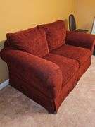 Ashley Furniture burgundy loveseat. 62X36x36 in tall. Seat height 18 in. Includes pillows and throws as shown in last photo.