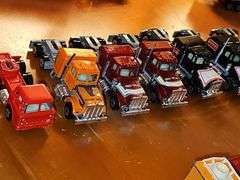 Grouping of diecast tractor-trailer toys and others from various makers.