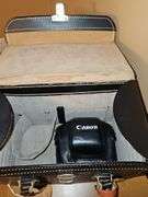 Single slide projector and leather camera bag with case for Canon camera. No camera included. Also includes a portable slide/movie screen.