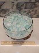 Beautiful molten glass bowl filled with sand and aqua blue crushed rock sitting on teak driftwood...