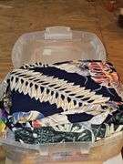 Small container of Hawaiian leis and shirts.