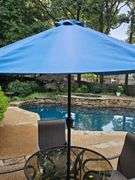 Glass top table, four swivel chairs, and umbrella.