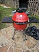 Red Kamado Joe Grill on rollaround iron stand w/cover and some like new accessories...