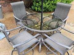 Glass top table, four swivel chairs, and umbrella.