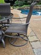 Glass top table, four swivel chairs, and umbrella.