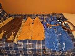 Little cowpoke leather chaps and vest in blue, natural leather color chaps, and pants with fringe and Teepee look on front, cowboy hat and drum.