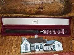 Miscellaneous grouping. Mikasa cake knife, Kirby farmhouse by the cat's meow, double, wicker breadbasket, and handled basket and placemats. See all photos for more details
