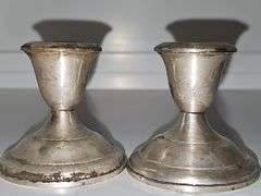 Pair of sterling weighted candlesticks. 2.75 in tall.