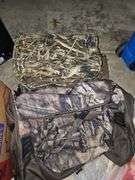 Two camo duffel bags. The smaller one has winter gloves in it.