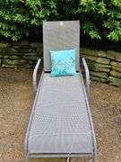 Adjustable patio lounge chair with cushion.