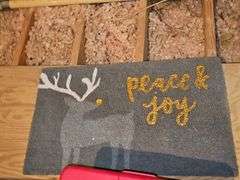 Tub of Christmas decor and doormat.