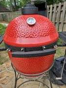 Red Kamado Joe Grill on rollaround iron stand w/cover and some like new accessories...