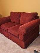Ashley Furniture burgundy loveseat. 62X36x36 in tall. Seat height 18 in. Includes pillows and throws as shown in last photo.