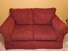 Ashley Furniture burgundy loveseat. 62X36x36 in tall. Seat height 18 in. Includes pillows and throws as shown in last photo.