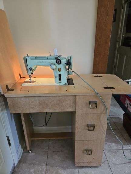 Vintage green singer sewing machine model 319W w/cabinet 29x16.75x32, knee pedal, foot control, and drawers full of accessories... image