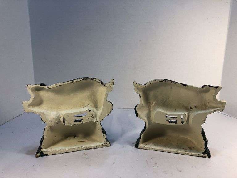 Vintage pair of cast iron black and white spotted pig book ends/door stops. 5 1/2” W x 5” H x 2”D.