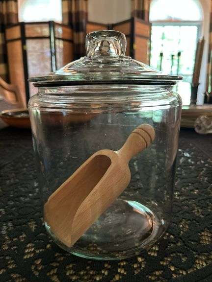 Clear glass candy/apothecary jar with lid and wooden scoop….6-5/8” D x 10” tall image