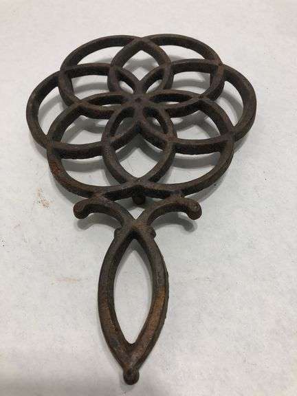 Vintage Wilton cast iron trivet. Concentric circle design forming a flower. 9 x 6”. Footed.