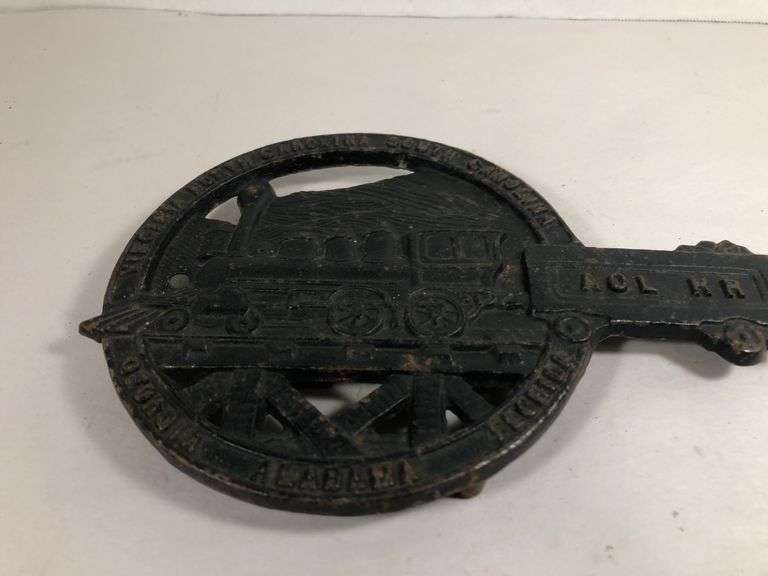 Vintage cast iron trivet featuring a steam locomotive and the text "ACL RR," which stands for the Atlantic Coast Line RR black trivet. VA Mertalcrafters #9-40   7 x 5 “