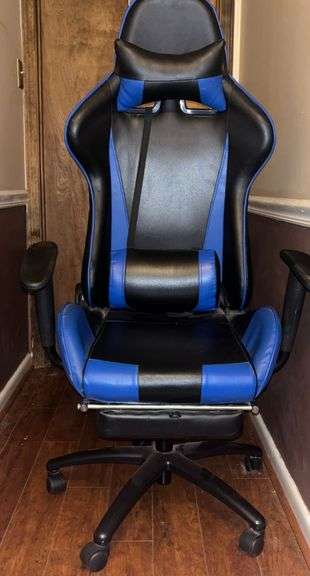 Blue and black rolling high back racing gaming chair, adjustable with foot rest.