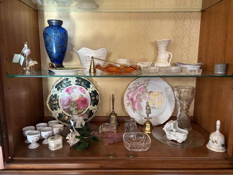 Contents of 2 bottom shelves in center part of china cabinet image