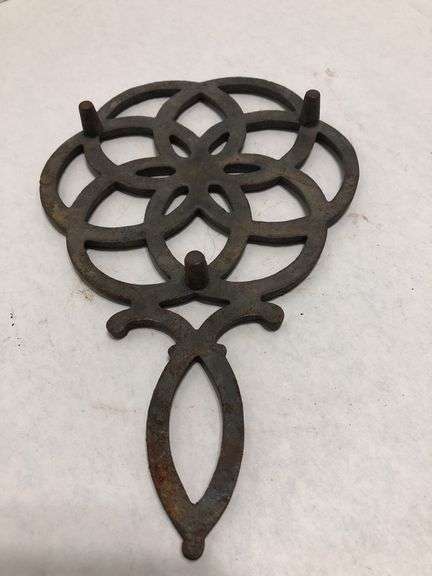 Vintage Wilton cast iron trivet. Concentric circle design forming a flower. 9 x 6”. Footed.