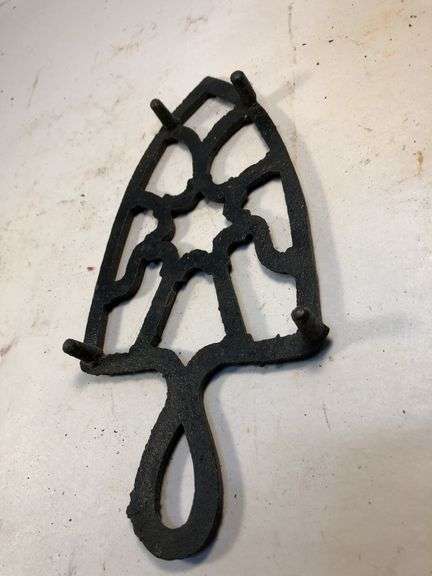 Vintage black, footed cast iron trivet. 7 x 3.5”