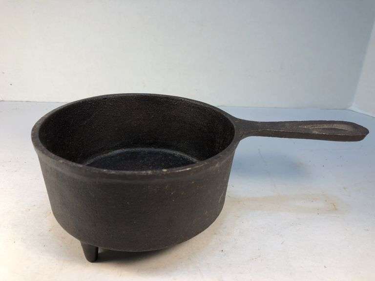 Antique "spider pot" with three legs and a gate mark. 2 7/8” h. 5” diameter. 6” L. image