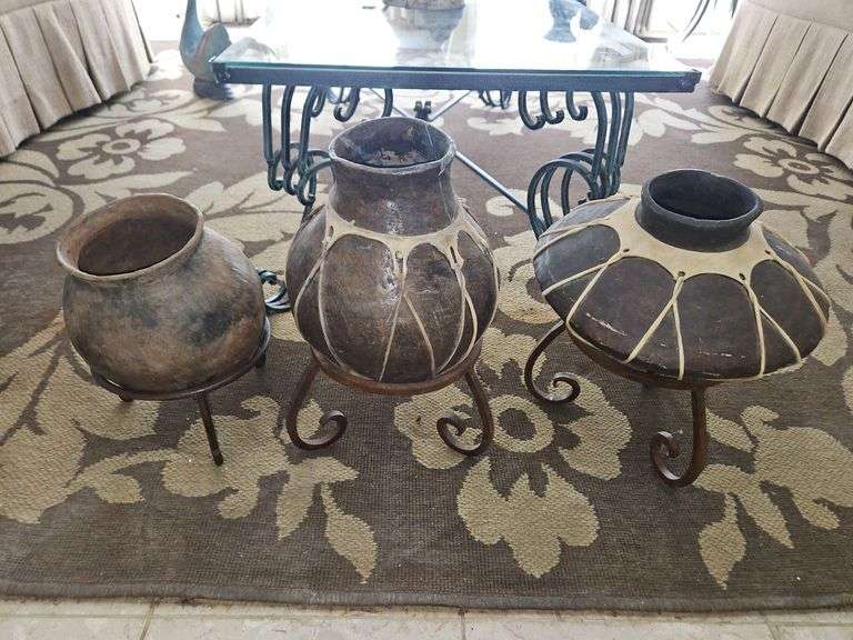 Group of three(3) unique pottery vases in short wrought iron stands... image