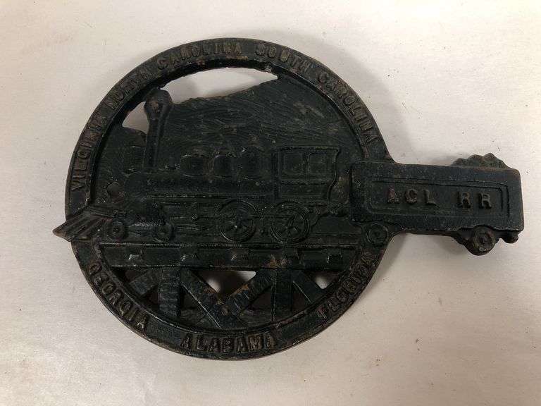Vintage cast iron trivet featuring a steam locomotive and the text "ACL RR," which stands for the Atlantic Coast Line RR black trivet. VA Mertalcrafters #9-40   7 x 5 “