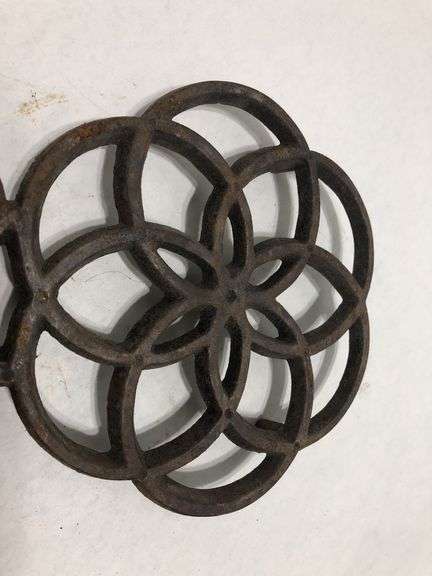 Vintage Wilton cast iron trivet. Concentric circle design forming a flower. 9 x 6”. Footed.