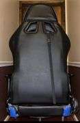 Blue and black rolling high back racing gaming chair, adjustable with foot rest.
