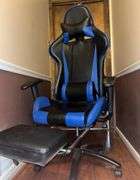 Blue and black rolling high back racing gaming chair, adjustable with foot rest.