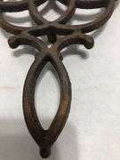Vintage Wilton cast iron trivet. Concentric circle design forming a flower. 9 x 6”. Footed.