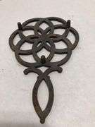 Vintage Wilton cast iron trivet. Concentric circle design forming a flower. 9 x 6”. Footed.