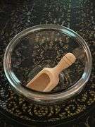 Clear glass candy/apothecary jar with lid and wooden scoop….6-5/8” D x 10” tall