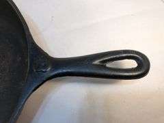Vi tage cast iron skillet with heat ring. Raised 8 on the front of handle. Ridge on the back ending in a triagular shape in pan side. 0 on back. No spin, no wobble.