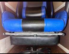 Blue and black rolling high back racing gaming chair, adjustable with foot rest.