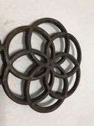 Vintage Wilton cast iron trivet. Concentric circle design forming a flower. 9 x 6”. Footed.