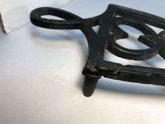 1800 to early 1900s cast iron footed trivet. 7.5 x 4”.
