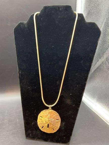 Gold tone sand dollar pendant on gold tone snake chain image