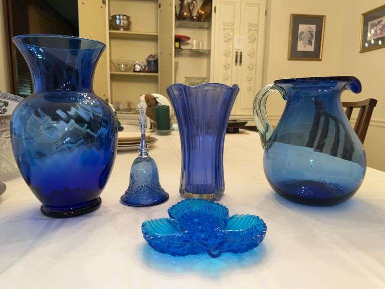 Nice collection of cobalt blue pieces…..from left - 11” tall swirl vase, vintage AVON bell perfume bottle, 8-1/2” tall Anchor Hocking scalloped edge vase, 9” tall hand blown pitcher and vintage Fenton leaf candy dish image