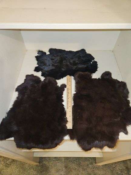 Three(3) beautiful animal fur pelts from unknown origin...two brown, one black... image