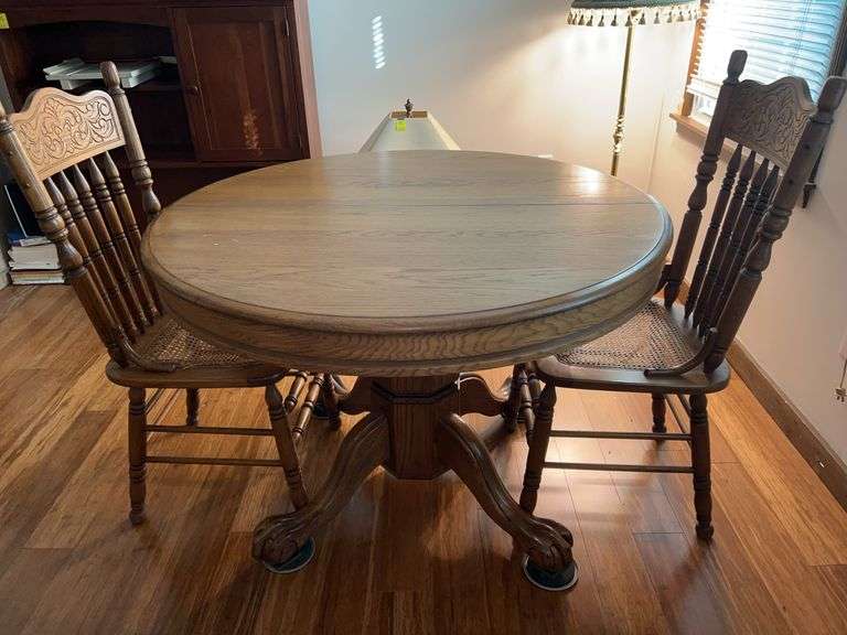 Solid oak farmhouse style round table with ball and claw feet and 2 chairs (both chairs need TLC…..cane seating need replaced and both are wobbly) image