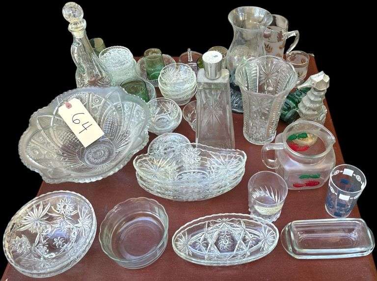 LARGE LOT OF CLEAR GLASSWARE TO INCLUDE 2 AVON BOTTLES, CANDLEHOLDER W/ GLASS GLOBE, LEAF PATTERN PITCHER W/ 2 MATCHING CUPS, PATTERN GLASS OVULAR BOWLS, PATTERN GLASS COASTERS, BRASWELL’S SELECT DRINKING GLASS, JUICE PITCHER, LARGE PATTERN GLASS BOWL, TOOTHPICK HOLDER, ANCHOR HOCKING WEXFORD RELISH DISH, MADISON AVENUE SMALL LEAD CRYSTAL VASE, ETC. image