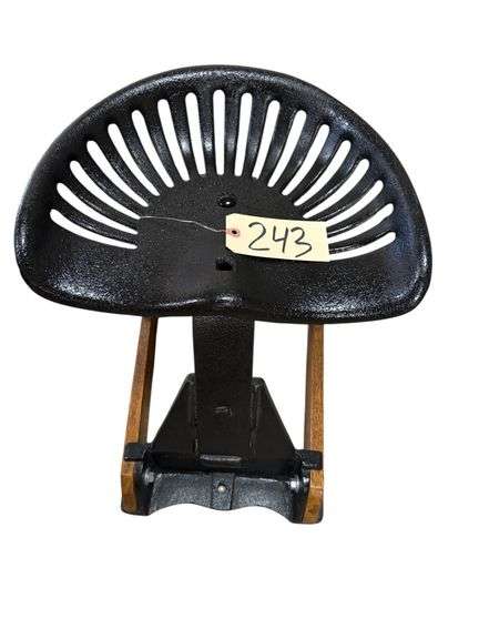 CAST IRON TRACTOR SEAT ON WOODEN STAND image
